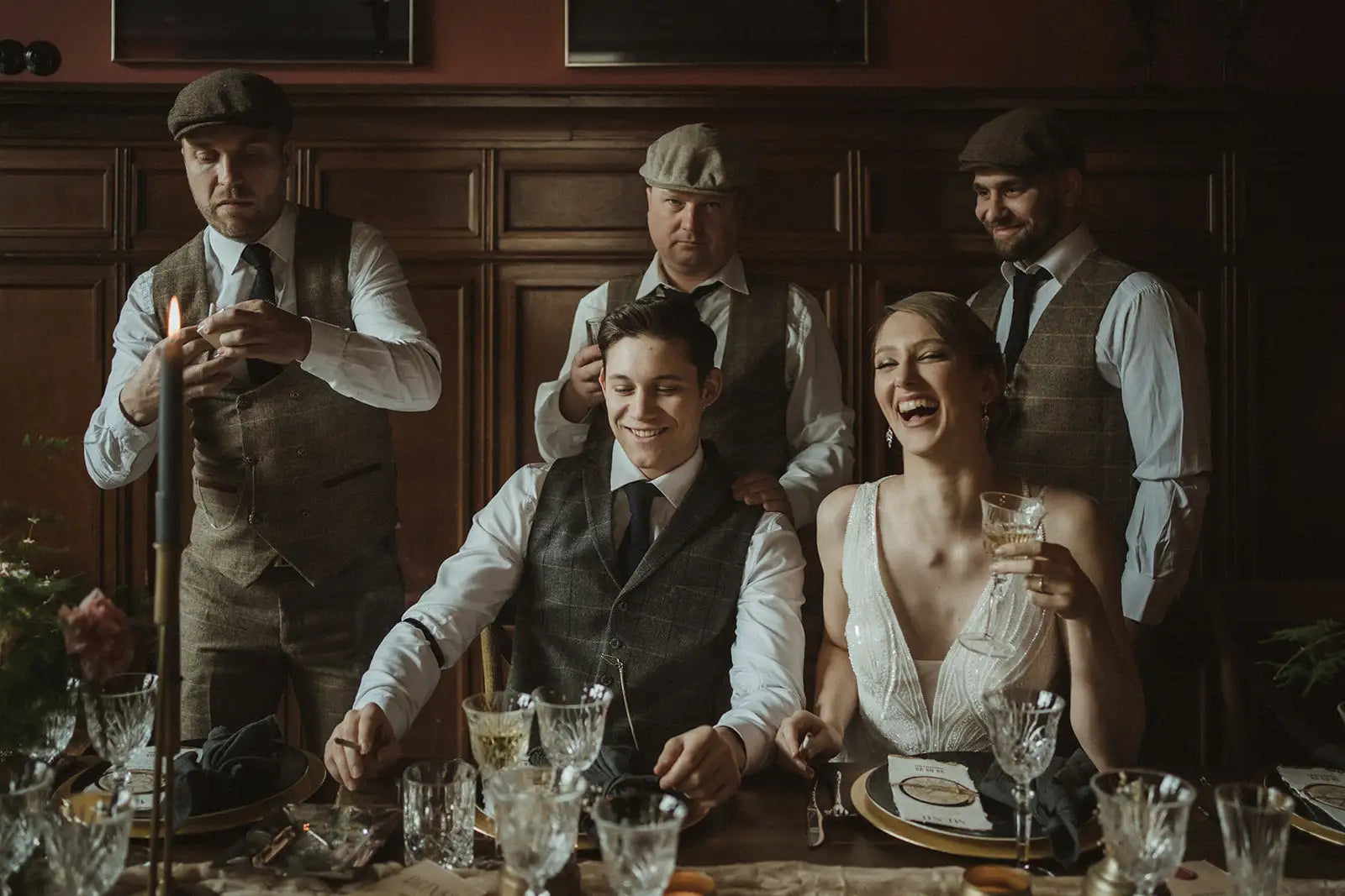 La mariée porte une robe de mariée blanche sans manches avec des détails en dentelle délicate et un décolleté plongeant.