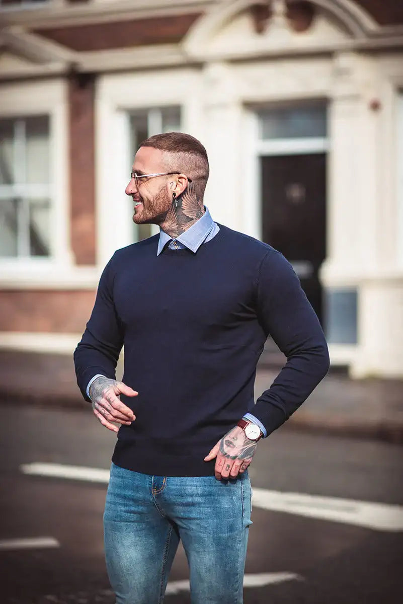Pullover bleu marine à col rond avec une texture côtelée subtile et un col soigneusement plié sur une chemise bleu clair